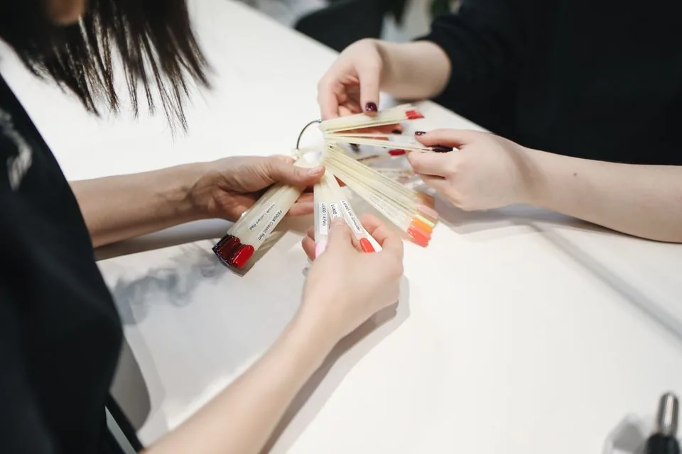Illustrative stock photograph of hands choosing a nail color